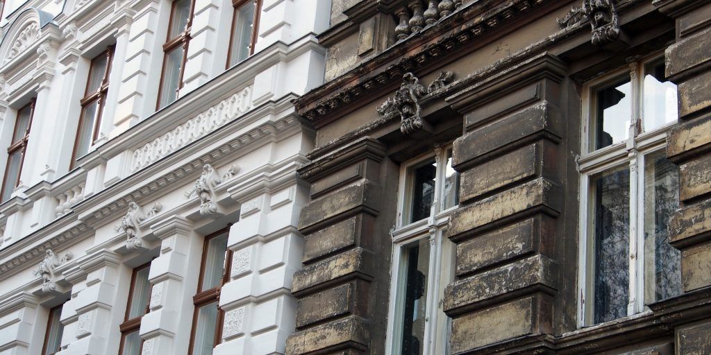 Fassade eines historischen Gebäudes, teils saniert, teils im Originalzustand